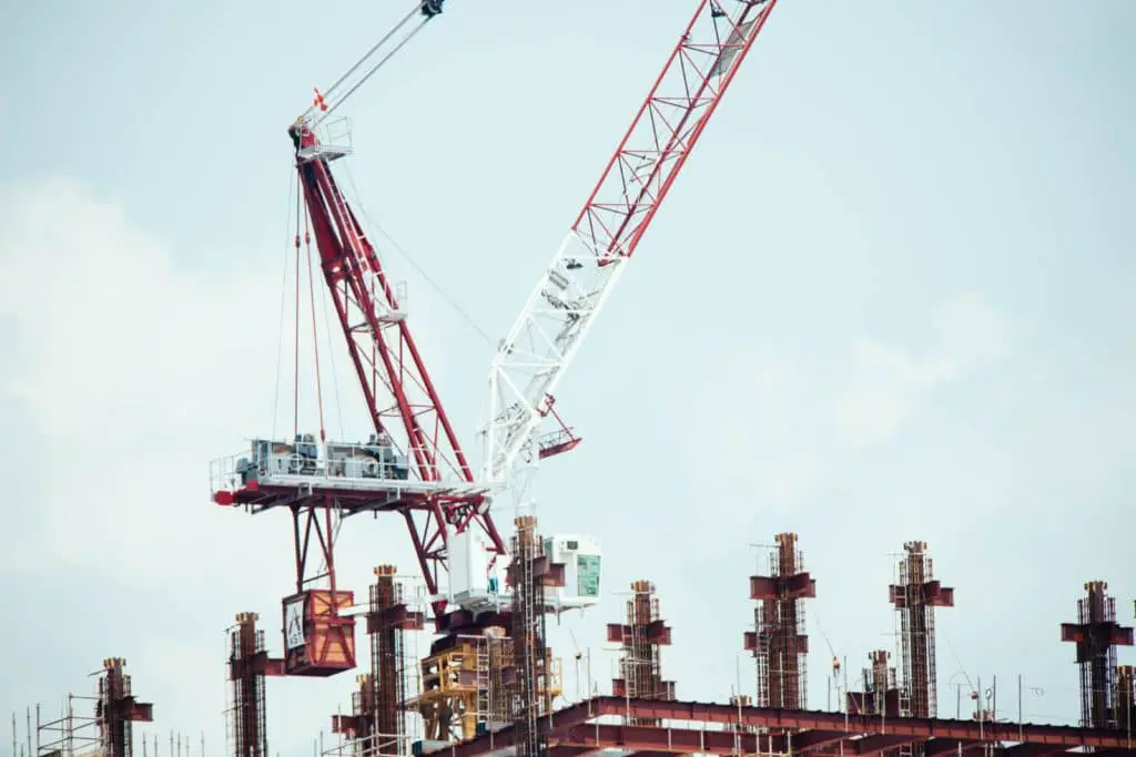 Red and white crane on a building construction site.